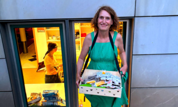 Eine Frau mit Bauchladen. Darin Eiscreme.