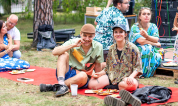 Menschengruppe sitzt im Garten und isst