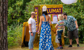 Menschen stehen um den "Illumat". Ein Automat der handgezeichnete Illustrationen nach eingeworfenen Wünschen auswirft.