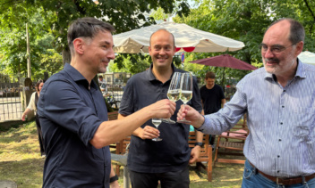 3 Männer stoßen mit Weingläsern an