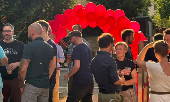 Menschengruppe bei Sonnenuntergang im Garten zur 20-Jahr-Feier von SandsteinNM