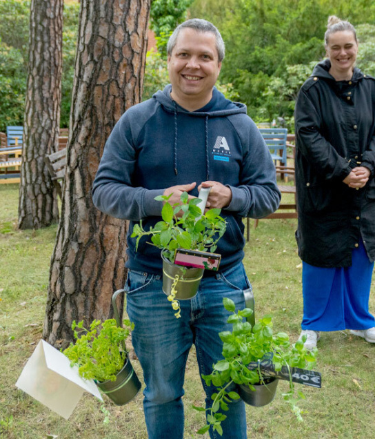 Bild eines Mannes mit Käutertöpfen in der Hand