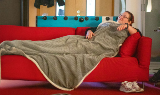 Frau auf Sofa mit Decke