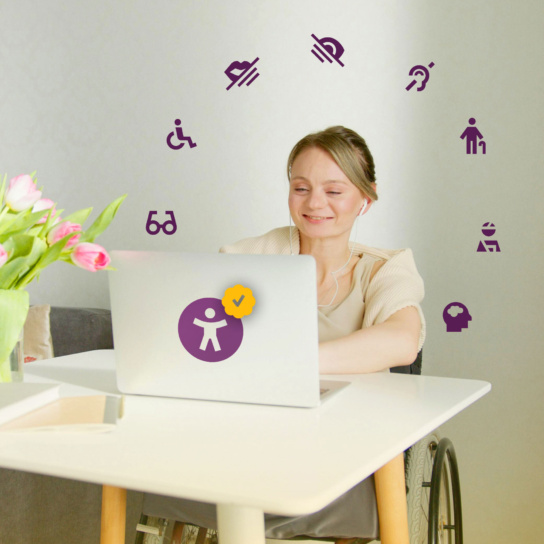 Lächelnde Frau sitzt im Rollstuhl an einem Schreibtisch. Vor ihr ein Laptop. Auf dem Foto sind Icons im Kreis angeordnet, die das Thema Barrierefreiheit behandeln.