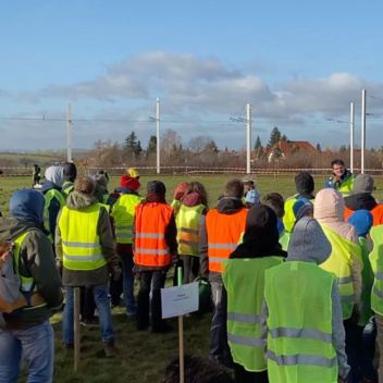 Eine Gruppe Menschen steht auf einem Feld.