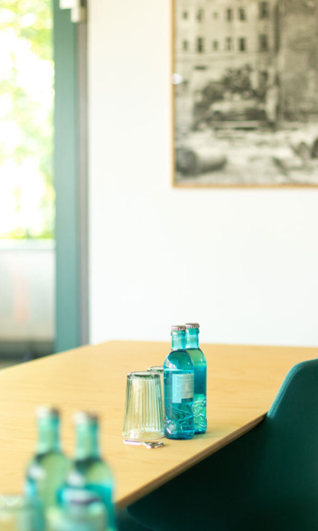 Besprechungsraum Obergeschoss: Detail Tisch mit blauen Wasserflaschen