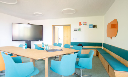 Besprechungsraum Obergeschoss: Blick zur Tür mit Sicht auf die Tische und Monitor