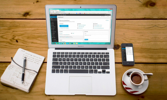 Foto: Laptop, Block und Stift und eine Kaffeetasse