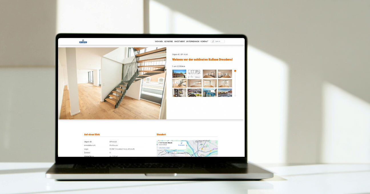 Heller Raum mit Laptop auf dem Tisch. Darauf eine Detailsseite der Website "Beate Protze Immobilien" zu sehen.