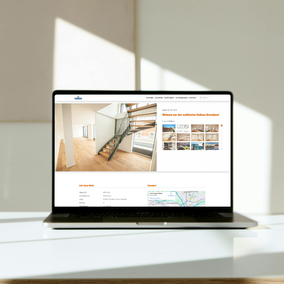 Laptop auf Tisch mit geöffneter Immobilien-Website, die eine helle Wohnung in Dresden zeigt