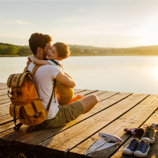 Foto: Kind umarmt Mann im Sonnenuntergang