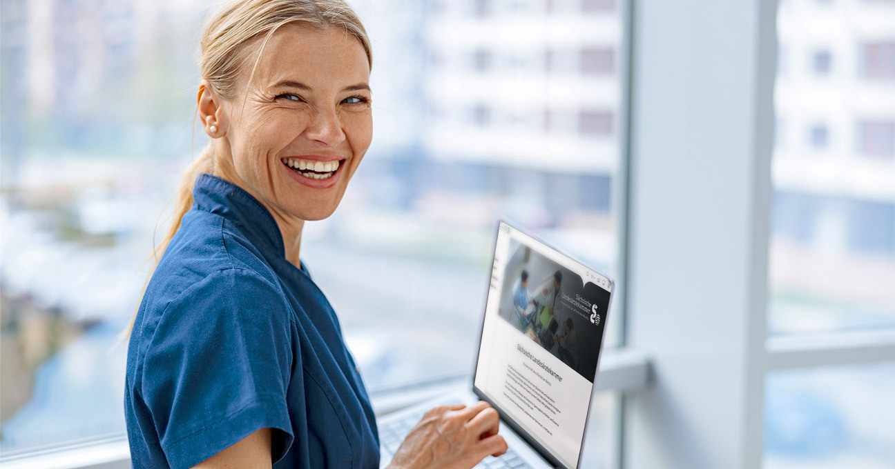 Ärztin hält einen Laptop mit Abbildung der släk-Webseite
