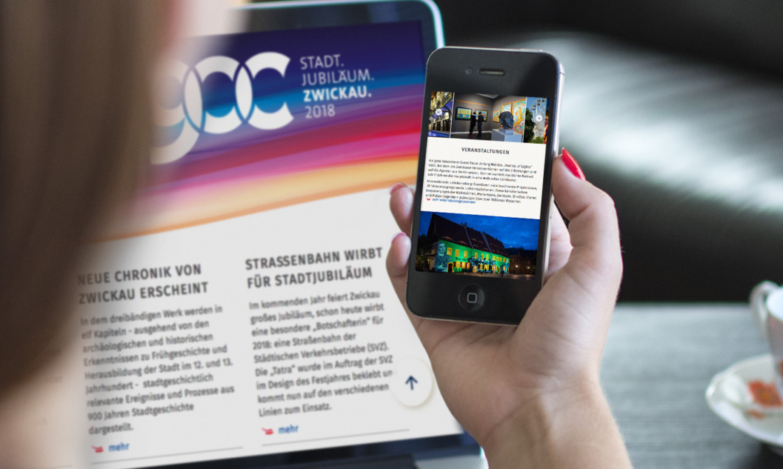 Grafik: Person hält Handy mit Zwickau Website