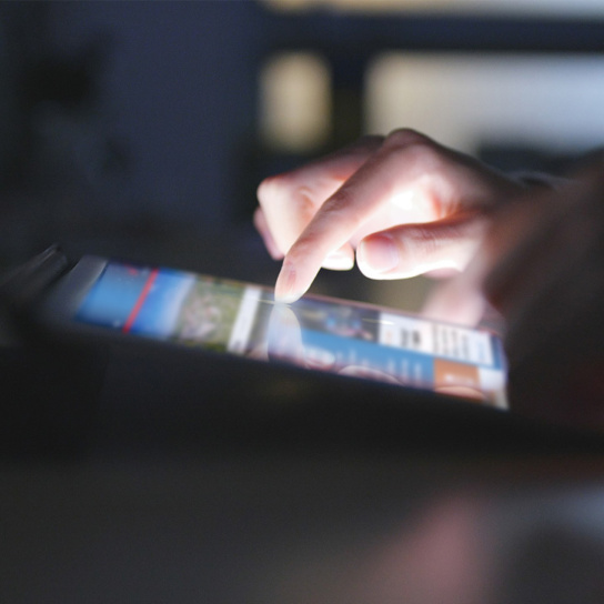 Grafik: Person bedient Tablet mit Zwickau Website, unten Logo von Stadt Zwickau