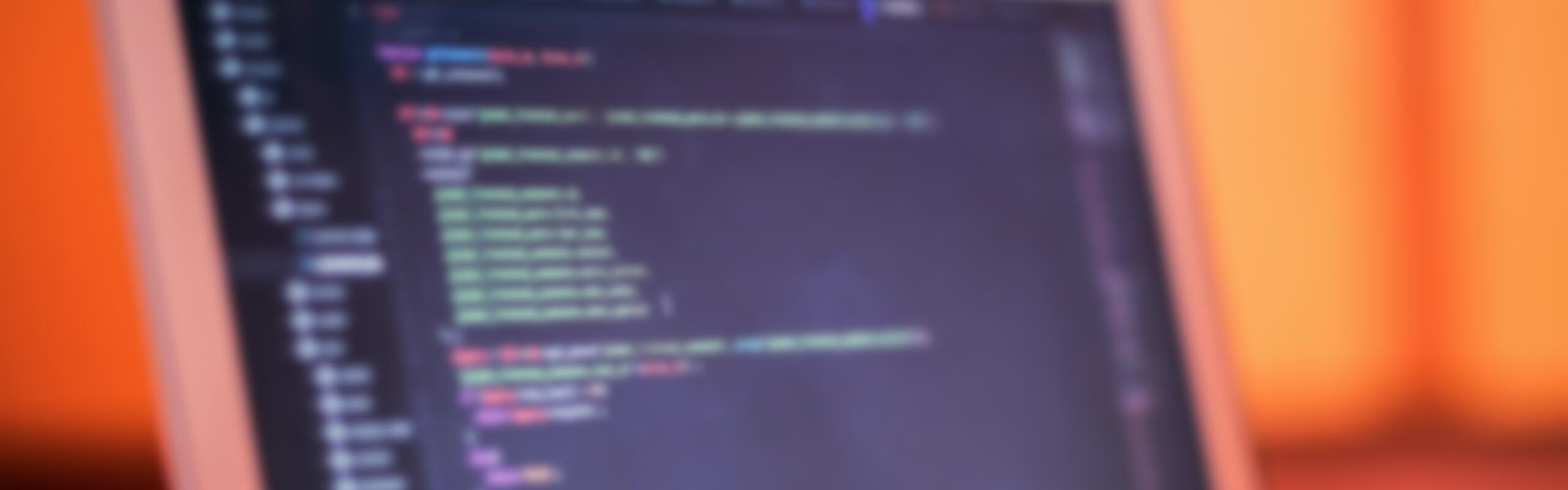 Grafik: verschwommener Hintergrund: Laptop mit Code