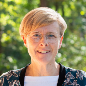 Bild einer Frau mit Brille und kurzen blonden Haaren
