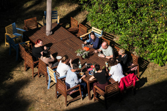 Foto: viele Person sitzen in Garten