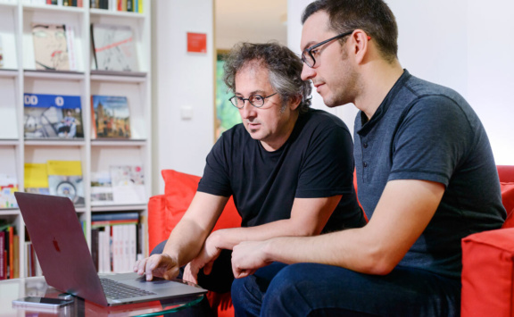 Foto: zwei Personen vor Laptop