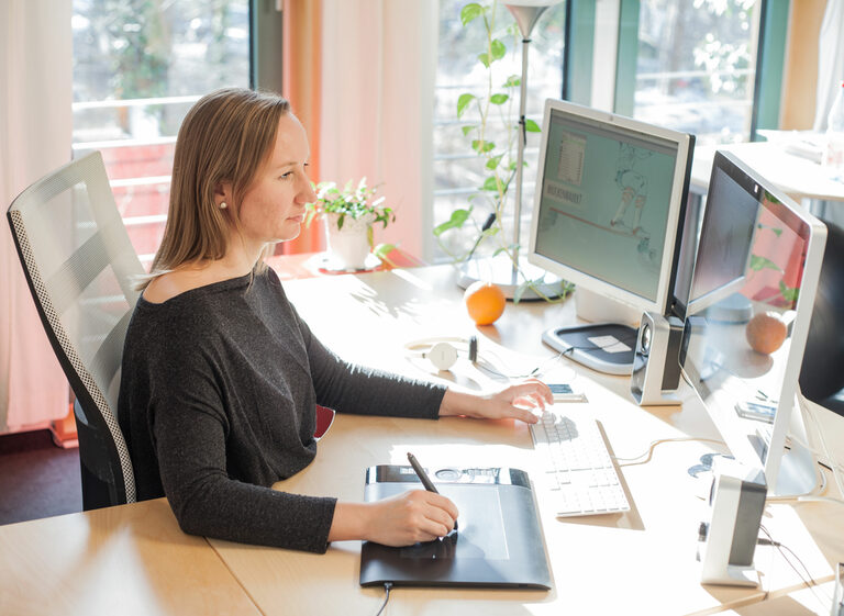 Mitarbeiterin arbeitet an ihrem Arbeitsplatz