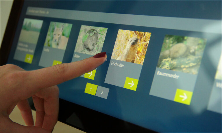 Sandstein als Multimedia Agentur realisierte ein interaktives Lexikon zum Thema Natur und Wildnis Foto: Finger tippt auf Bildschirm