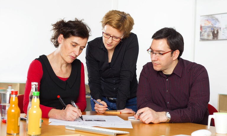 Sandstein Neue Medien hilft beim Reptutationsmanagement. Foto: Drei Personen bei einer Besprechung.