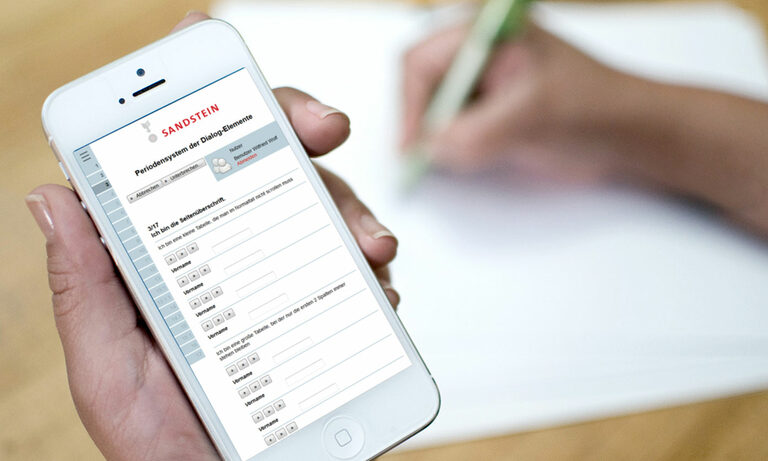 Mockups zur Visualisierung von Elementen und responsivem Verhalten Foto: Hand hält Smartphone mit Webseite von Sandstein.