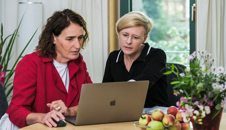 Foto: Zwei Personen vor einem Laptop